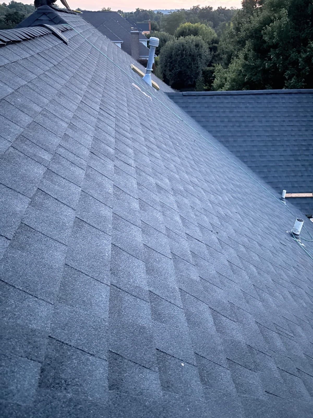 Ridge cap shingles running along the peak of a new architectural asphalt roof on a North Jersey home — the highest point of the roof, one of the two points borough zoning uses to measure building height