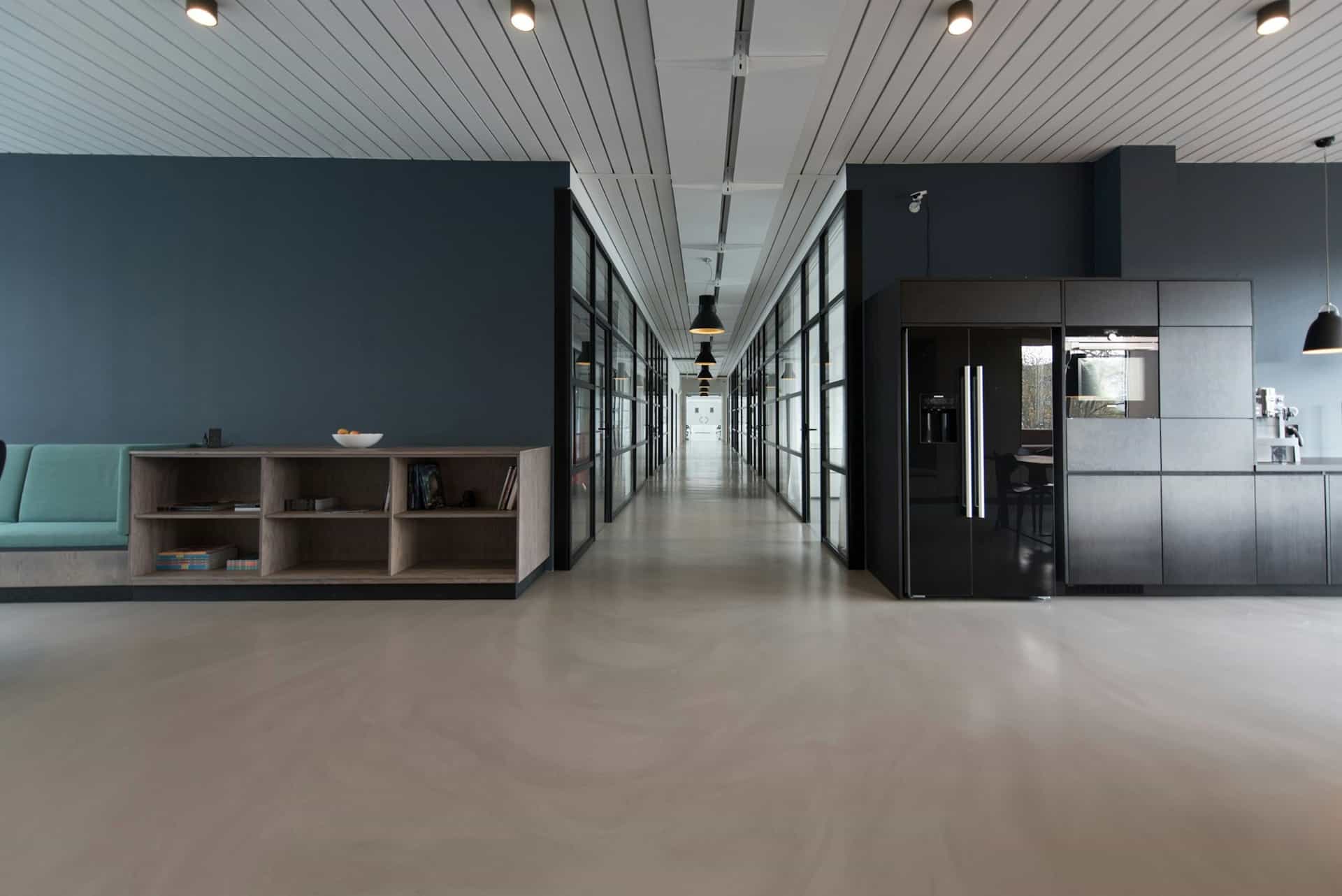 Office corridor lined with black-framed glass partition walls