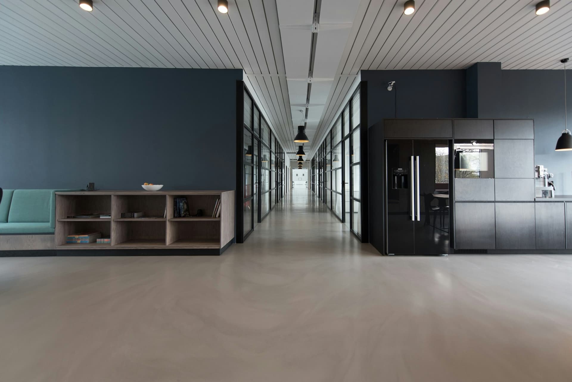 Office corridor lined with black-framed glass partition walls