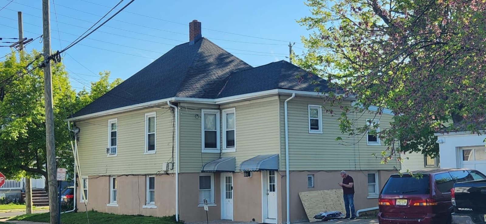 Completed architectural asphalt shingle hip roof on a two-family New Jersey home after a full tear-off and new plywood decking