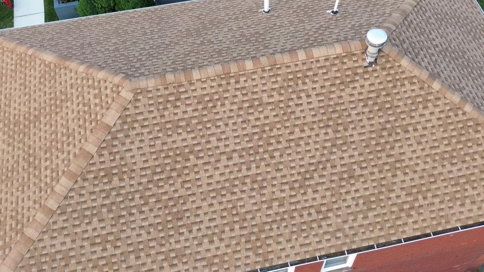 Detail of the ridge and hip lines on the completed Lodi, NJ roof, with capped hips meeting the ridge vent at the peak