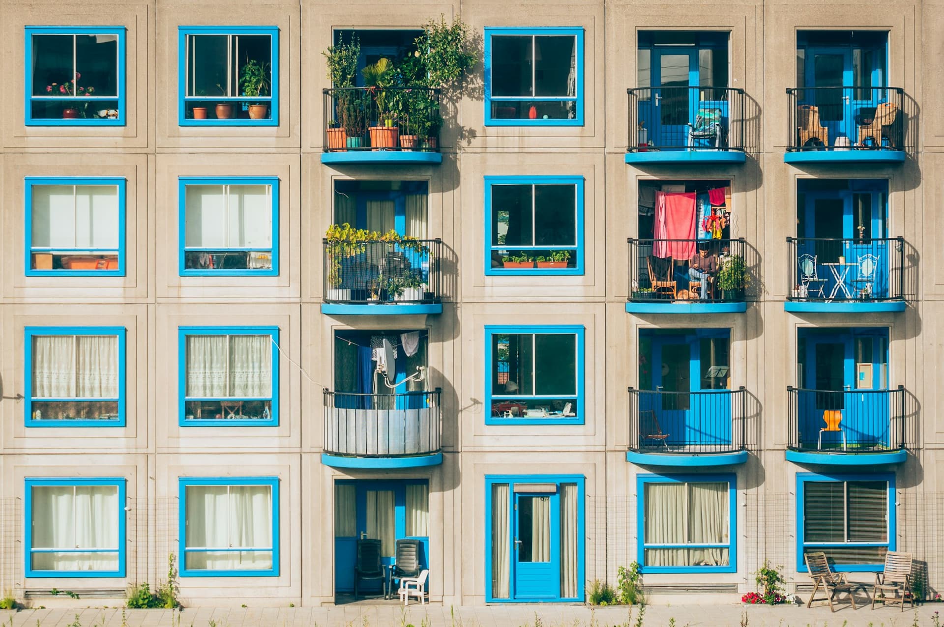 Apartment building facade with blue-framed windows and curved balconies