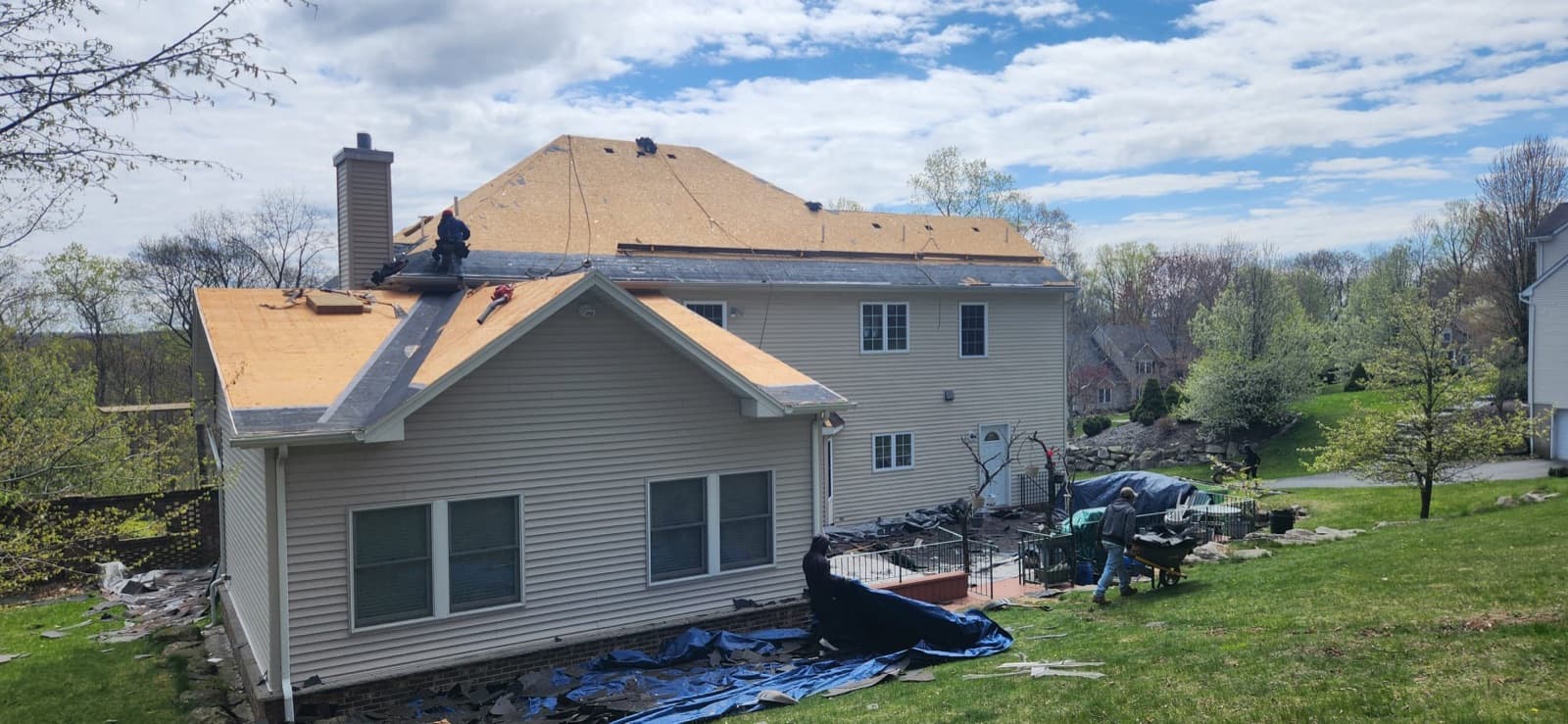 Precision crew installing new roof decking and underlayment over a large New Jersey colonial after a full tear-off