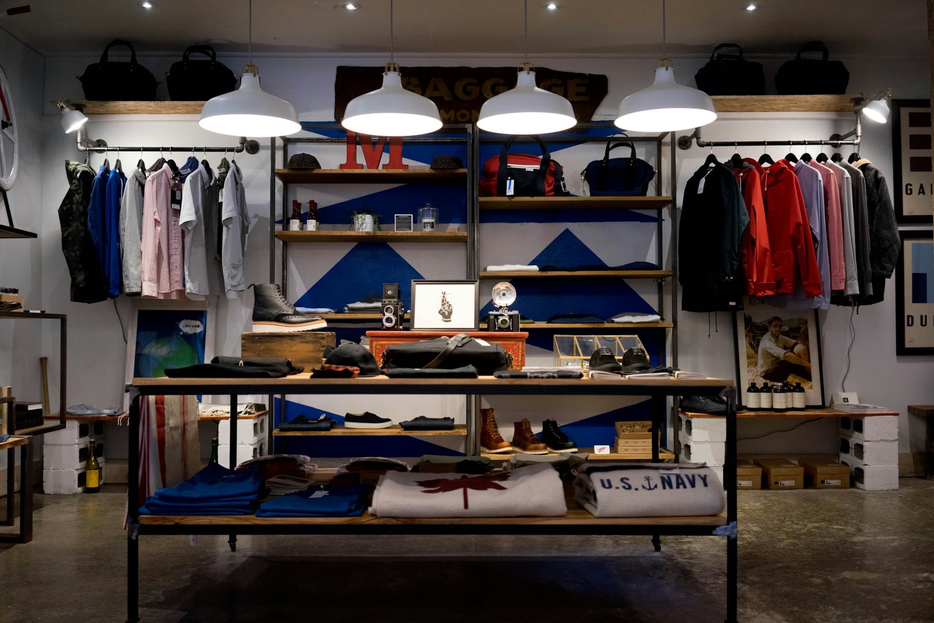 Clothing boutique interior with shelving, clothes racks and pendant lamps